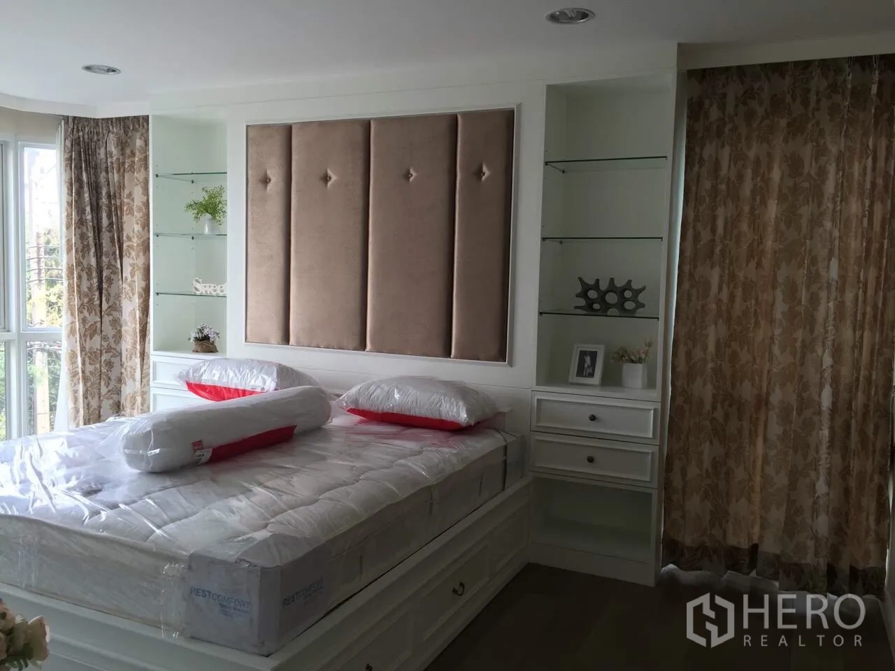 คอนโด ให้เช่าในKhlong Toei, Bangkok - ห้องนอนใหญ่หัวเตียงบุผ้า ผ้าม่านลายดอก และชั้นกระจกบิวท์อิน