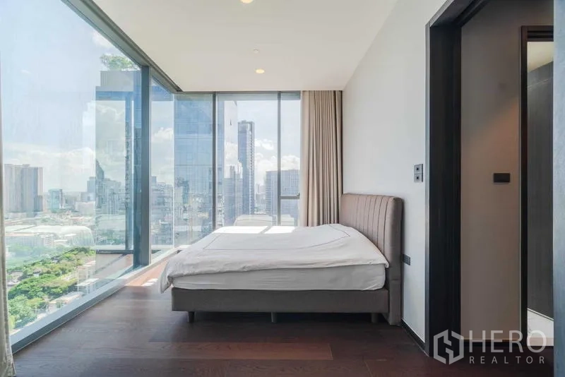 Condominium for rent or sale - Bedroom with large windows on two sides and expansive cityscape views.
