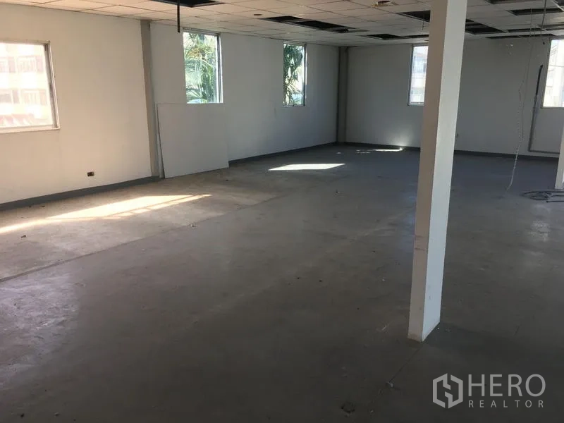 Warehouse for rent in Suan Luang, Bangkok - Empty open-plan office floor with windows, support columns, suspended ceiling and concrete floor ready for fit-out.