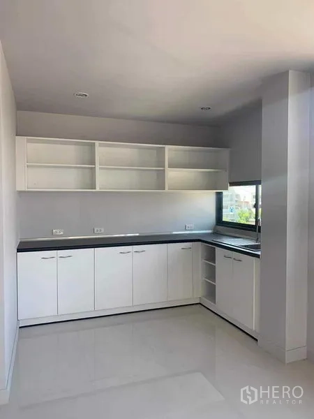 Townhouse for rent or sale in Yan Nawa, Bangkok - White built-in pantry with open shelves, L-shaped countertop and sink.