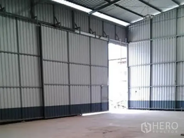 Warehouse for rent in Sai Mai, Bangkok - Spacious warehouse interior with high steel truss roof, wide sliding doors and durable concrete floor.