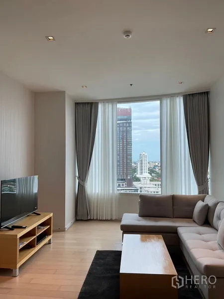 คอนโด ให้เช่าในWatthana, Bangkok - ห้องนั่งเล่นพร้อมโซฟา ชั้นวางทีวี และหน้าต่างสูงมองเห็นวิวกรุงเทพฯ