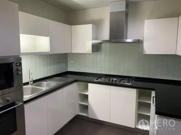 คอนโด ให้เช่าในWatthana, Bangkok - ภาพระยะใกล้ของครัวพร้อมอ่างล้างจานคู่ เคาน์เตอร์หินสีดำ และผนังกระเบื้อง