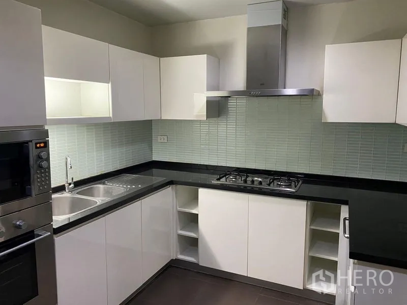 คอนโด ให้เช่าในWatthana, Bangkok - ภาพระยะใกล้ของครัวพร้อมอ่างล้างจานคู่ เคาน์เตอร์หินสีดำ และผนังกระเบื้อง