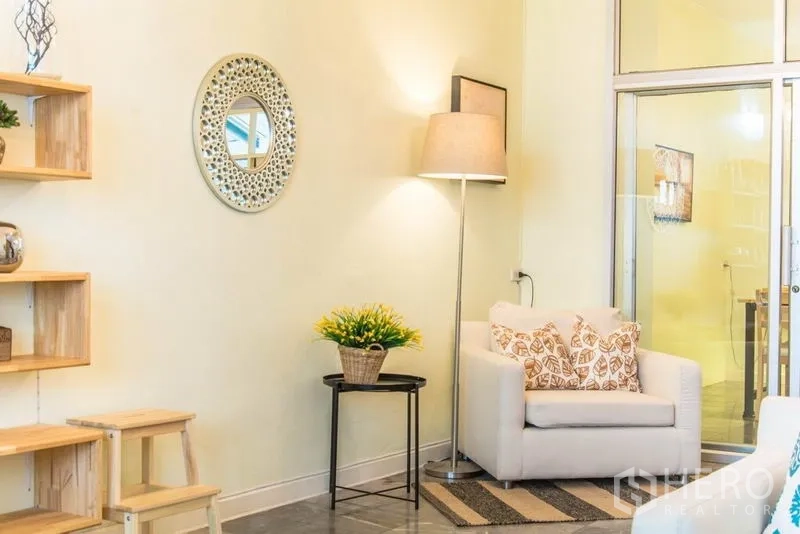 带办公室的家 出租在Suan Luang, Bangkok - 舒适角落，单人沙发、落地灯与圆镜靠近玻璃门。