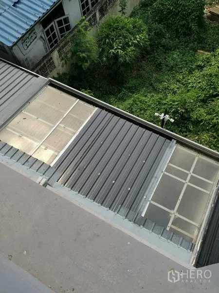 Home Office for rent or sale - Overhead view of metal and translucent roof panels covering a service area.
