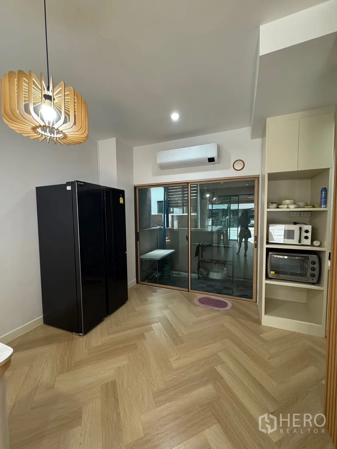 Townhouse for rent in Saphan Sung, Bangkok - Kitchen and dining area with black refrigerator and glass partition.