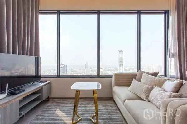 Condominium for rent in Watthana, Bangkok - Sofa and TV beside a full-width window with a small marble table and panoramic city view.