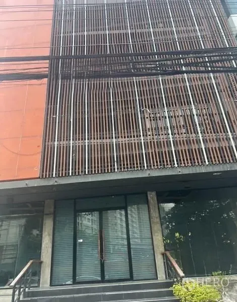 อาคารพาณิชย์ ให้เช่า - ด้านหน้าช็อปเฮาส์สมัยใหม่หลายชั้น พร้อมระแนงโลหะแนวตั้ง ประตูกระจก และบันไดทางเข้า
