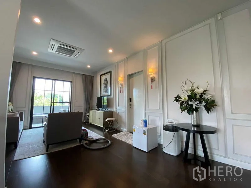 บ้าน ขายในPrawet, Bangkok - ห้องนั่งเล่นสว่าง มีประตูกระจกเปิดสู่ระเบียง พื้นไม้ และไฟดาวน์ไลท์