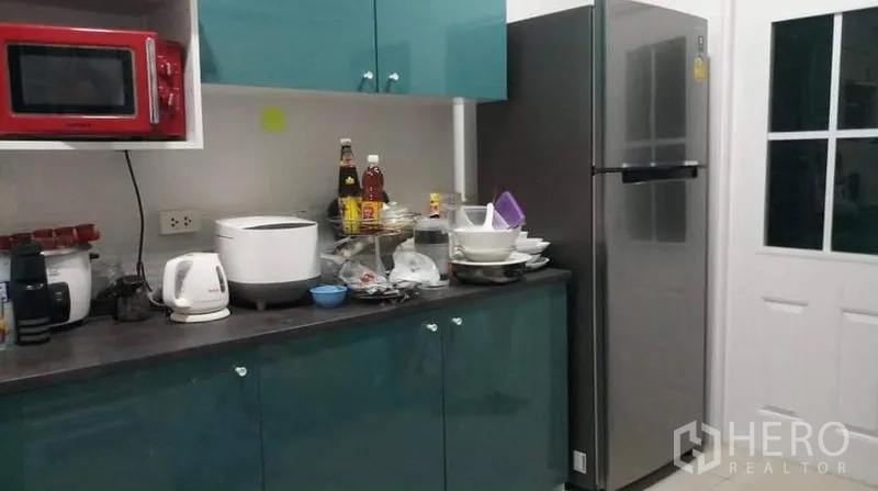 บ้าน ให้เช่าหรือขายในPrawet, Bangkok - ครัวพร้อมตู้บิวท์อินสีเขียว เครื่องใช้ไฟฟ้า และตู้เย็นสแตนเลส