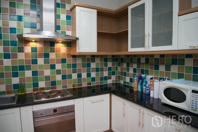 คอนโด ให้เช่าในKhlong Toei, Bangkok - ครัวตัวแอล เคาน์เตอร์หินสีดำ เตาอบ เตาไฟฟ้า และตู้บิลท์อินสีขาว