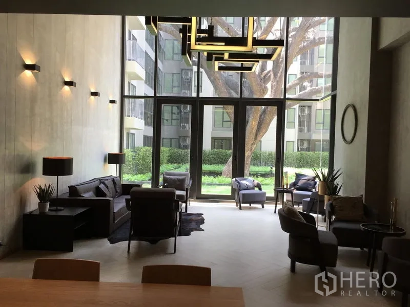 คอนโด ขายในPhaya Thai, Bangkok - เลานจ์ส่วนกลางเพดานสูง มีโซฟาสมัยใหม่และมุมมองสวน