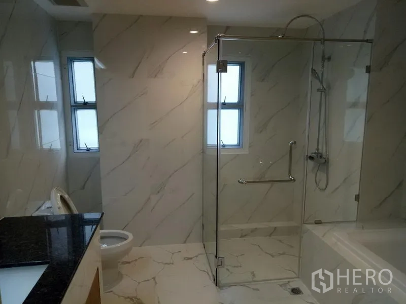 Apartment for rent in Khlong Toei, Bangkok - Marble bathroom with glass shower enclosure, bathtub and long vanity