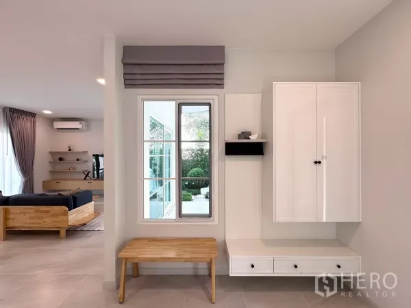 Detached House for rent in Bang Phli, Samut Prakan - Entry hall with built-in cabinet, bench and window facing the garden, opening to the living area.