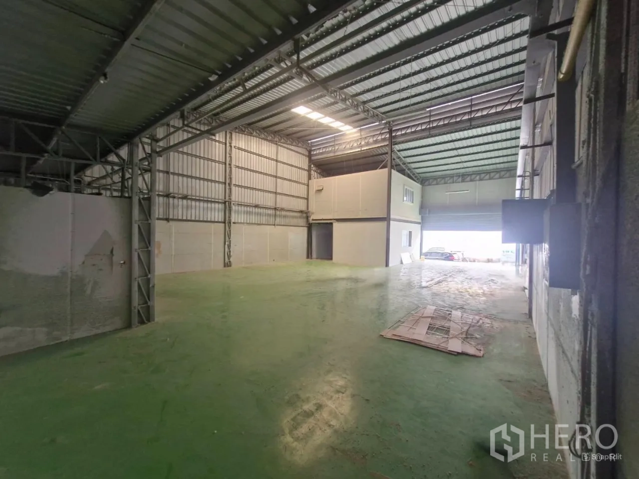คลังสินค้า ให้เช่าในThung Khru, Bangkok - ภายในโกดังมองไปทางประตูทางเข้าพื้นลาดสีเขียว