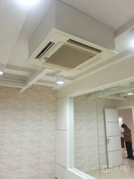 Office Space for rent - Ceiling cassette air-con unit above a mirrored wall in a modern office interior.
