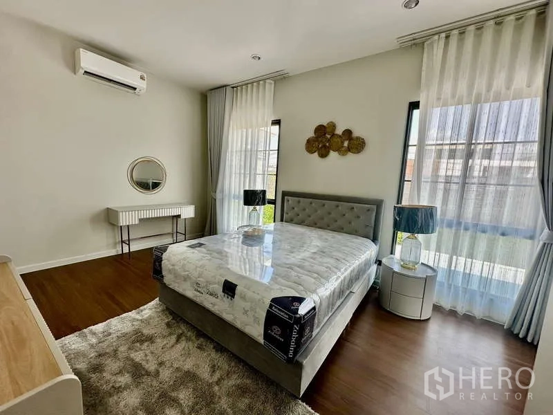 独立式住宅 出租在Bang Phli, Samut Prakan - 转角卧室，三面窗，配置床与床头柜。