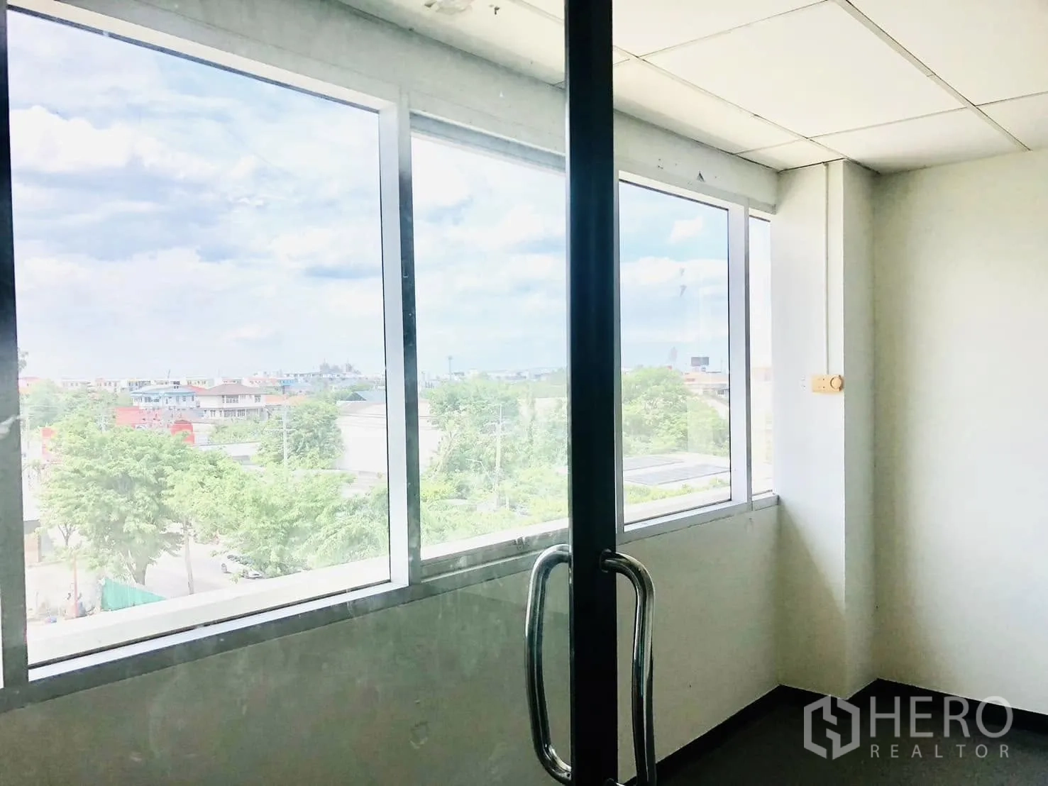 Office Space for rent in Lat Phrao, Bangkok - Corner office by a glass door featuring wide windows and city views.