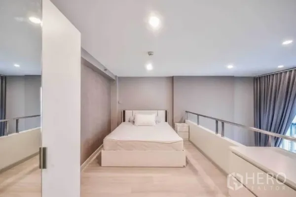 Condominium for rent in Sathon, Bangkok - Loft-style mezzanine bedroom with queen bed, glass railing and recessed lights in a modern Bangkok condo.