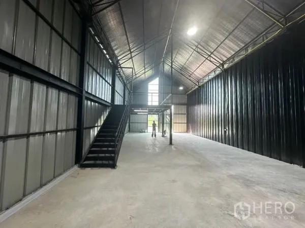 货栈 出租在Bueng Kum, Bangkok - 仓库纵深视角，楼梯通往夹层，配有高窗天光。