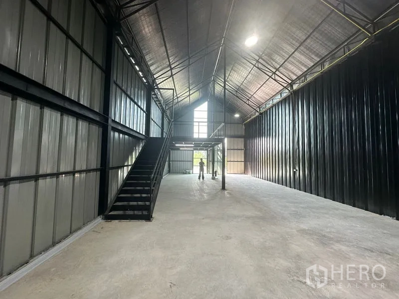 货栈 出租在Bueng Kum, Bangkok - 仓库纵深视角，楼梯通往夹层，配有高窗天光。