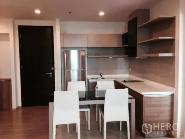 คอนโด ให้เช่าในKhlong Toei, Bangkok - ครัวเปิดสมัยใหม่ พร้อมตู้บิลท์อิน เตาไฟฟ้า ตู้เย็น และโต๊ะทานอาหาร 4 ที่นั่ง