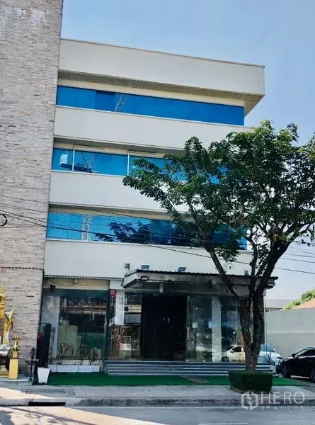 店屋 出租在Lat Phrao, Bangkok - 拉抛多层商铺外观，蓝色玻璃窗与一层玻璃入口，现代立面。