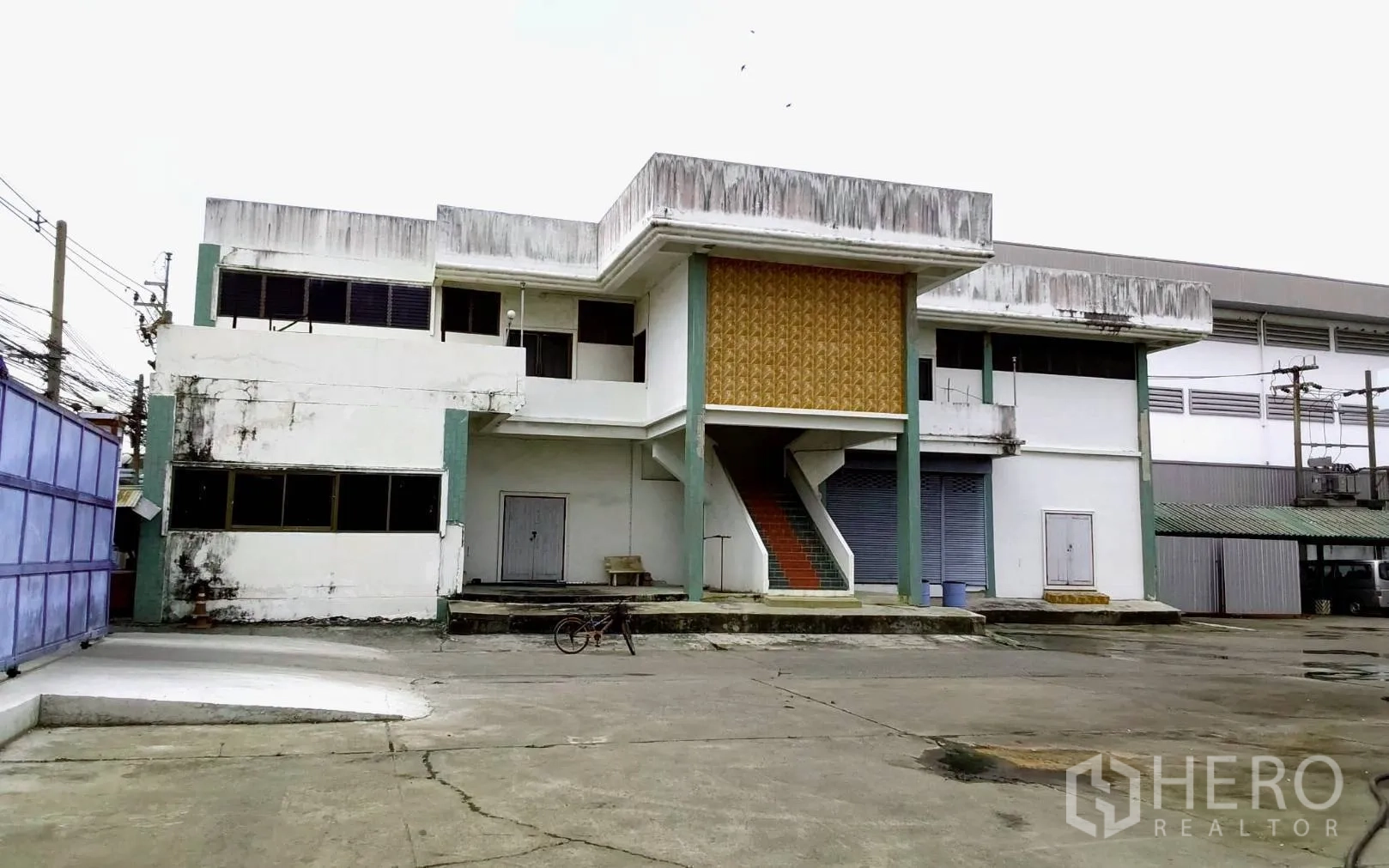 Factory for rent or sale in Bang Phli, Samut Prakan - Secondary front building with external staircase and roller shutters.