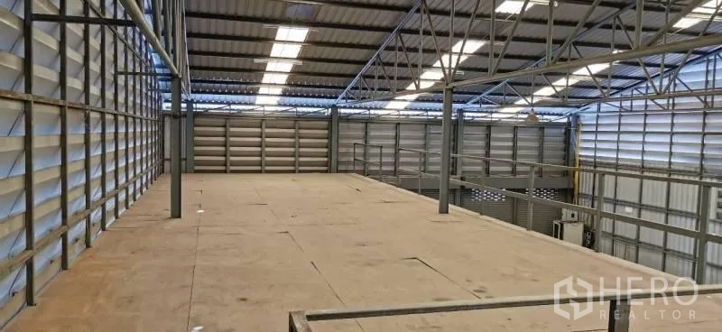Warehouse for rent in Huai Khwang, Bangkok - View from the mezzanine showing open warehouse floor and truss roof with skylights.
