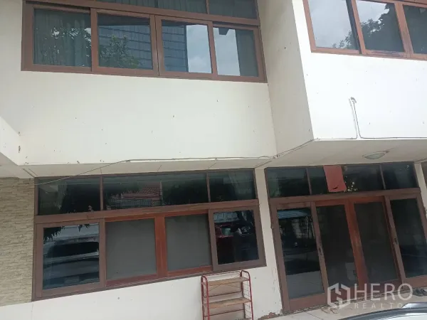 Detached House for rent in Bang Rak, Bangkok - Ground-floor entrance of the home with wooden-framed sliding doors and wide windows.