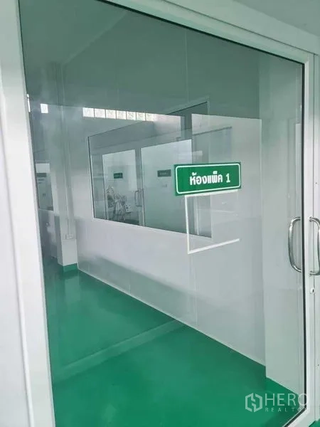 工厂 出售在Bang Pa-in, Phra Nakhon Si Ayutthaya - 标示“包装室1”的玻璃门，内为洁净工作区。