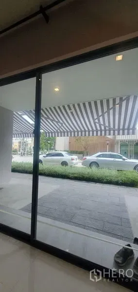 สำนักงานที่บ้าน ให้เช่าในPrawet, Bangkok - หน้าตากระจกชั้นล่าง มองออกไปที่กันสาดลายทางและที่จอดรถริมถนน