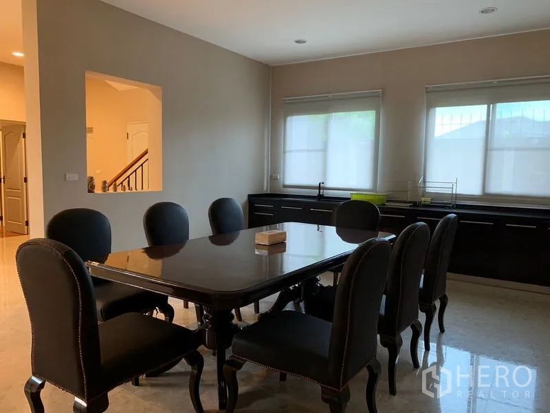 Detached House for rent or sale in Khan Na Yao, Bangkok - Dining room with eight-seat table, dark upholstered chairs and side counters.