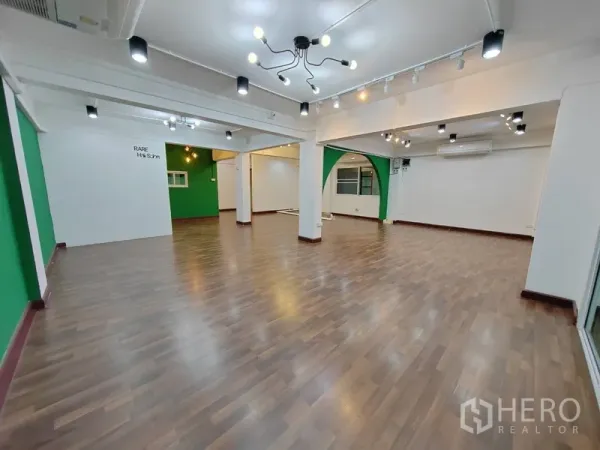 พื้นที่ขายปลีก ให้เช่าในKhlong Toei, Bangkok - พื้นที่ภายในแบบโอเพ่นโล่ง ปูพื้นลามิเนต ไฟราง และผนังสีเขียว