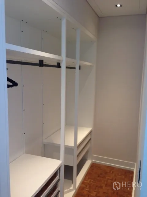 Condominium for rent or sale in Bang Rak, Bangkok - Walk-in closet with open shelving, drawers and hanging rails in a modern condo.