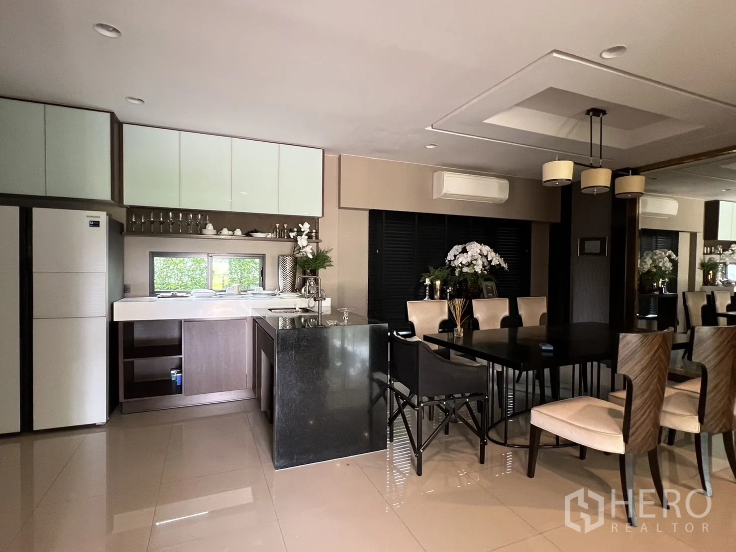 Detached House for rent or sale in Bang Kapi, Bangkok - Pantry kitchen with white cabinets, island and adjoining dining set.