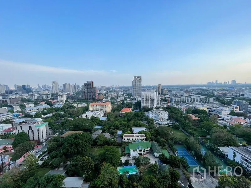 公寓 出售在Khlong Toei, Bangkok - 高楼阳台远眺曼谷天际线与周边葱郁社区景观。