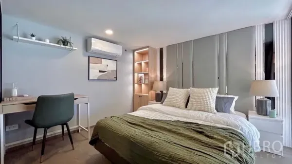 Condominium for rent - Cozy bedroom with a work desk, open shelving, air conditioning and warm ambient lighting.