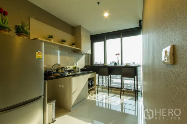 公寓 出租或出售在Sathon, Bangkok - 现代厨房，浅木柜体、黑色台面、不锈钢冰箱，窗边城市景观吧台。