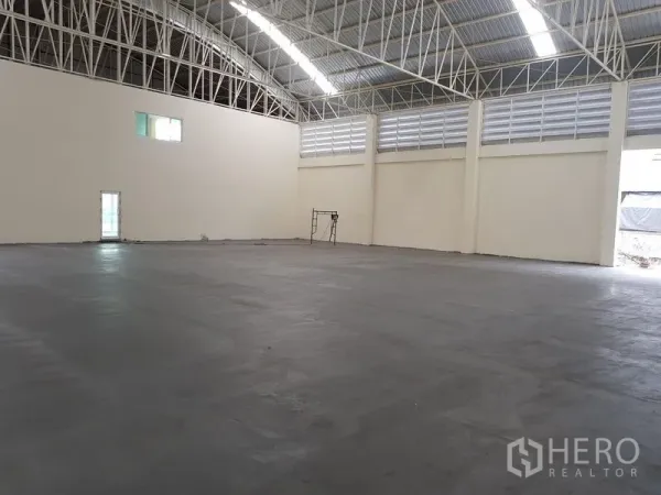 Factory for rent or sale in Mueang Samut Prakan, Samut Prakan - Expansive factory hall with high arched steel roof and smooth concrete floor.