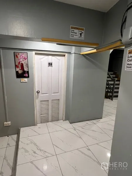 พื้นที่ขายปลีก ให้เช่าในKhlong Toei, Bangkok - โถงทางเดินภายใน ป้ายเตือนเพดานต่ำ มีประตูบริการและทางขึ้นบันได.