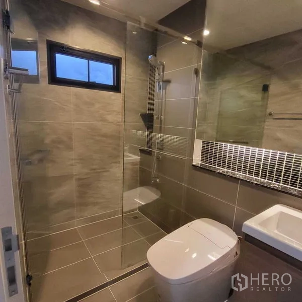 Detached House for rent in Mueang Pathum Thani, Pathum Thani - Contemporary bathroom with glass-enclosed shower and wall-hung toilet