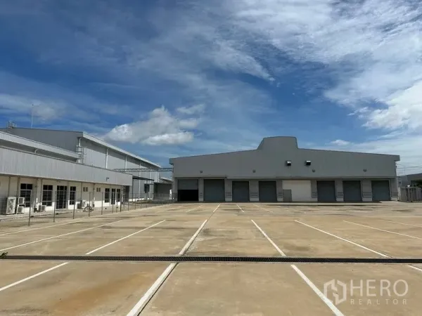 工厂 出租在Bang Sao Thong, Samut Prakan - 建筑正面，多个卷帘装卸月台与划线停车位
