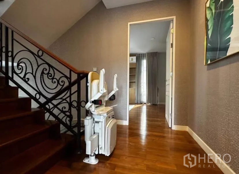 ทาวน์เฮาส์ ให้เช่าในYan Nawa, Bangkok - บันไดราวเหล็กดัดพร้อมเก้าอี้เลื่อนขึ้นบันได พื้นไม้เงางาม