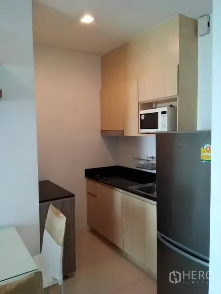 คอนโด ให้เช่าในWatthana, Bangkok - ครัวบิวท์อินตู้ไม้สีอ่อน ท็อปหินสีดำ ไมโครเวฟ และตู้เย็น