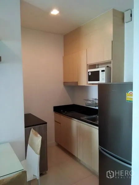 คอนโด ให้เช่าในWatthana, Bangkok - ครัวบิวท์อินตู้ไม้สีอ่อน ท็อปหินสีดำ ไมโครเวฟ และตู้เย็น