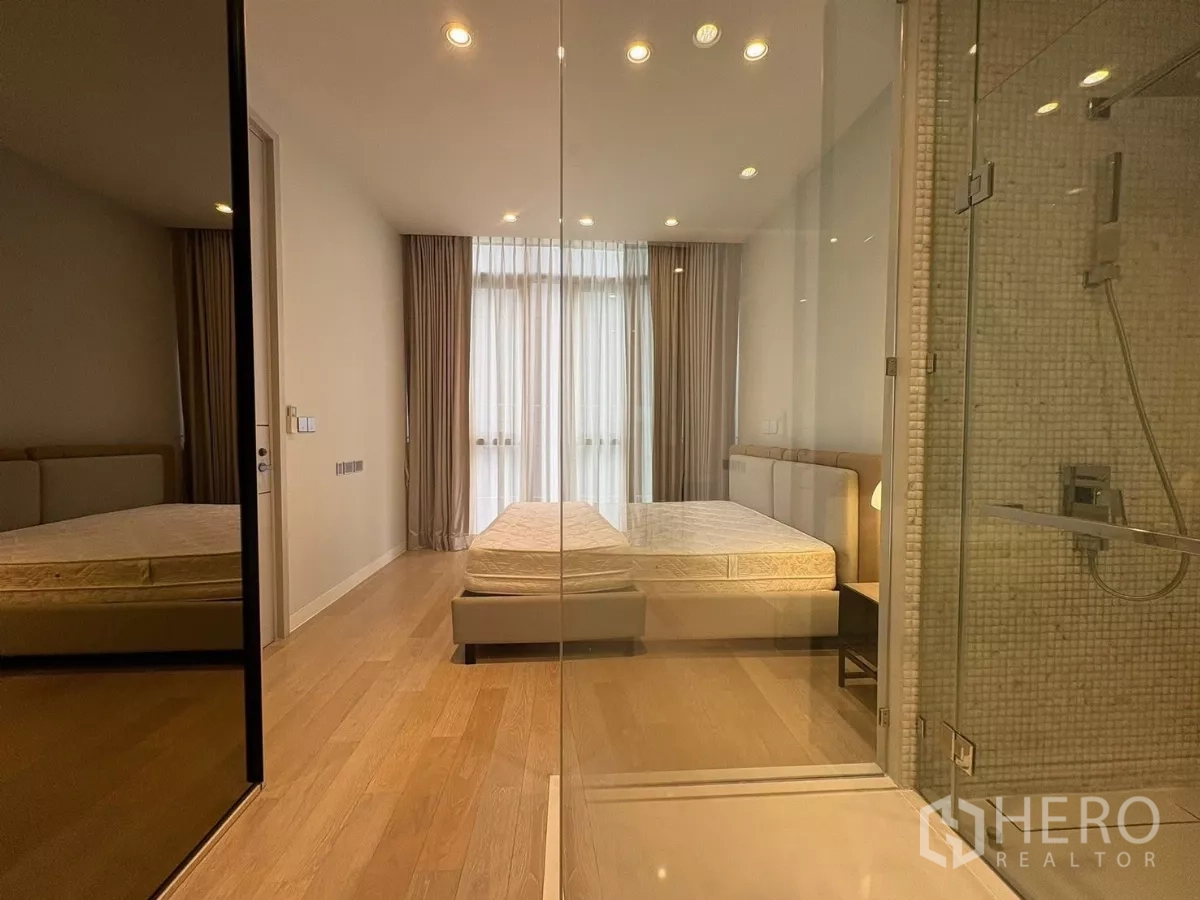 คอนโด ให้เช่าในWatthana, Bangkok - มุมมองห้องนอนที่สองผ่านผนังกระจกของฝักบัวและตู้เสื้อผ้า