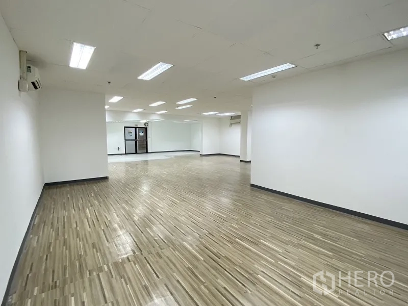 零售空间 for rent in Khlong Toei, Bangkok - 开放式室内空间，木纹地板、白色墙面与嵌入式顶灯。
