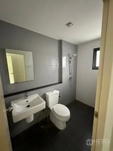 บ้าน ขายในBang Khen, Bangkok - ห้องน้ำโทนเทา‑ขาวพร้อมฝักบัวและช่องแสง.